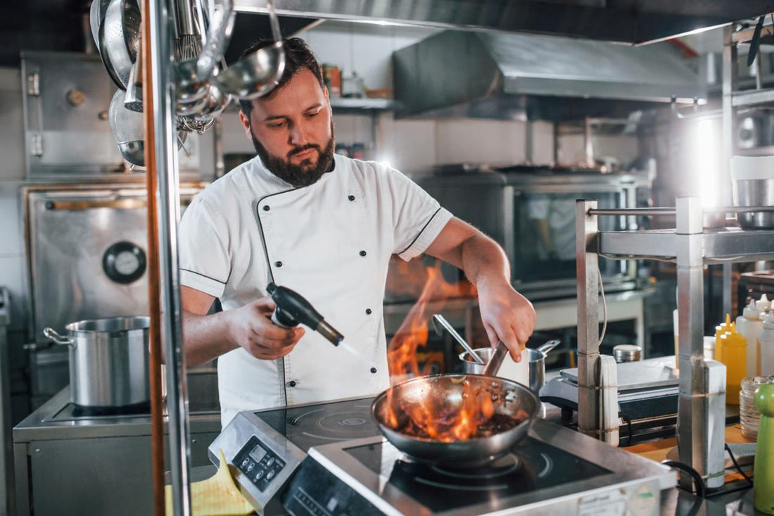 chef using culinary blow torch safely in kitchen close up