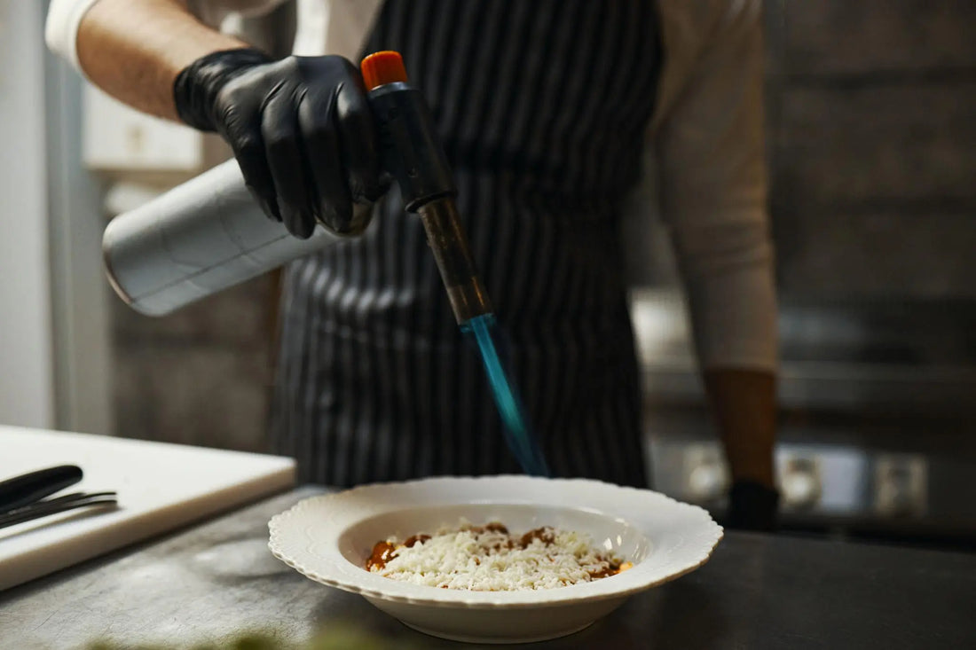 professional culinary blow torch with blue flame close up